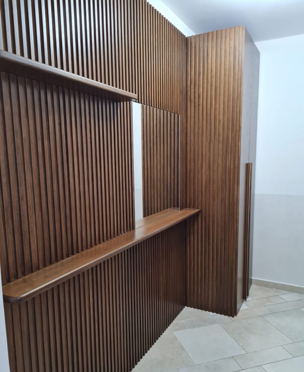 Boiserie in listelli di noce con mensola e pannelli su misura in ingresso