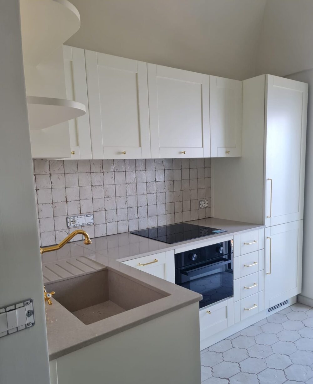 Cucina bianca in stile classico con maniglie dorate, rubinetto in ottone e rivestimento in cementine
