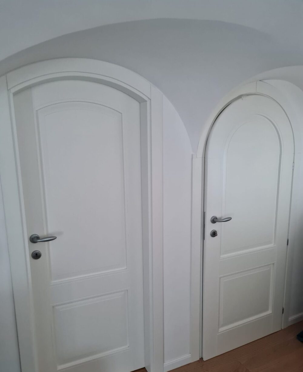 Porte interne bianche, una classica e una ad arco, su parquet in rovere